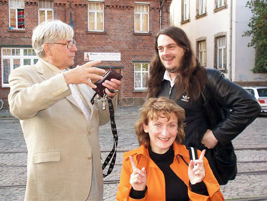 Demütig knieend verweist Amanuensis auf ihren Meister Bazon Brock und auf die Meese Jonathan unter Einsatz aller verfügbaren Indexfinger als Ausdruck niemals enden wollender Verehrung für Künstler mit und ohne Werk, Baumwollspinnerei Leipzig, September 2006 (Foto: Ulrich Giersch)